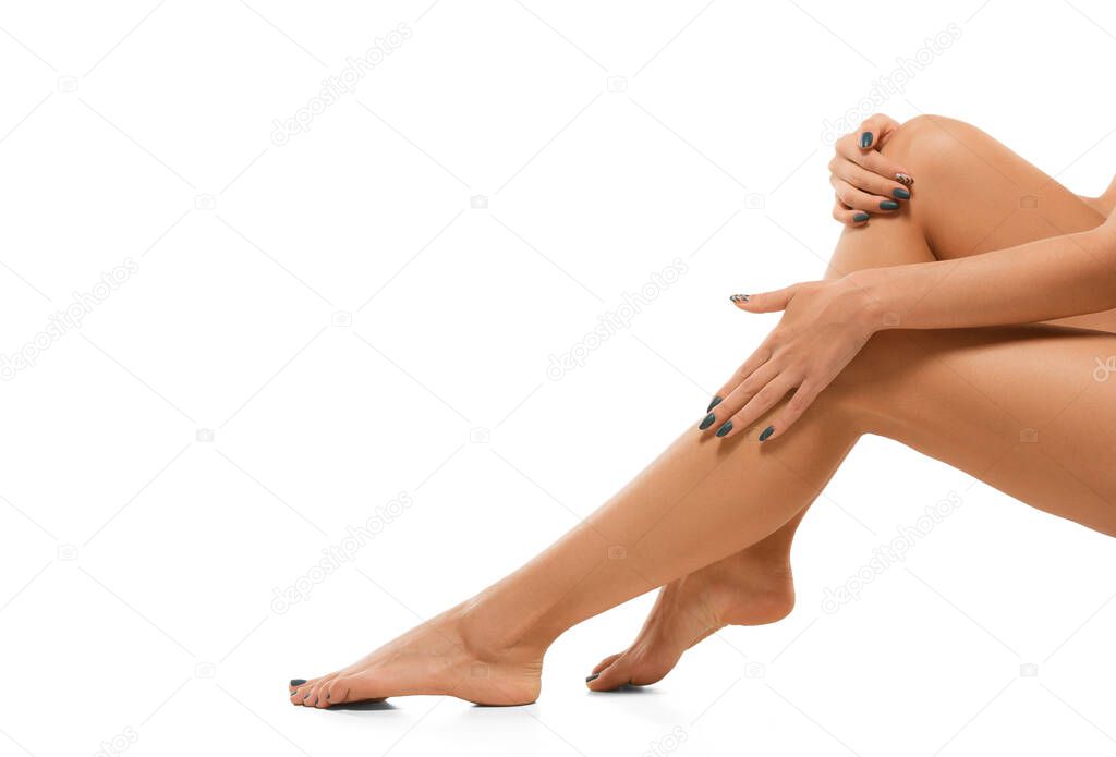 Beautiful female legs isolated on white background. Beauty, cosmetics, spa, depilation, treatment and fitness concept, sensual posing
