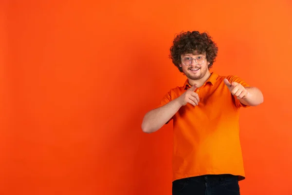 Kaukasiska unga män monokrom porträtt på orange studio bakgrund — Stockfoto