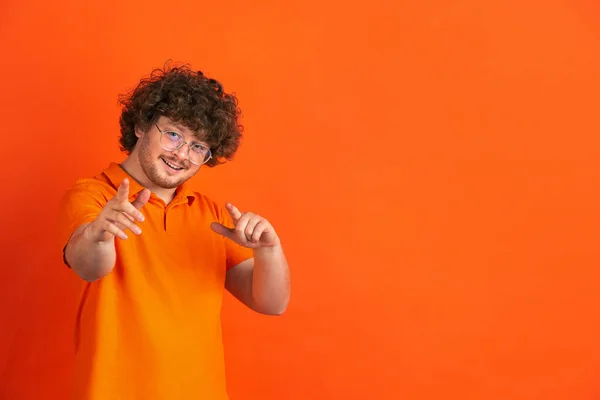 Caucásico joven mans monocromo retrato en naranja estudio fondo —  Fotos de Stock