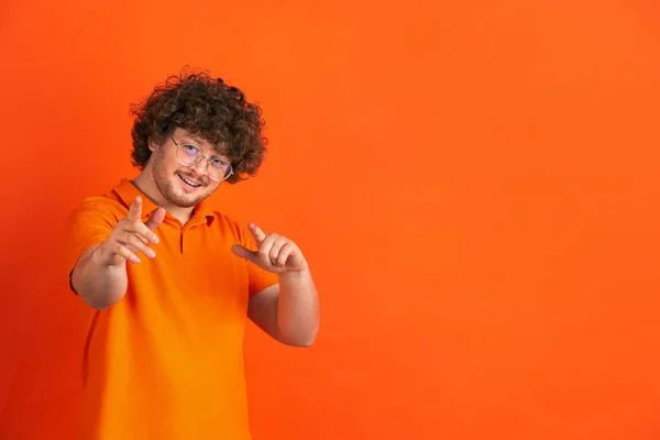 Kaukasiska unga män monokrom porträtt på orange studio bakgrund — Stockfoto