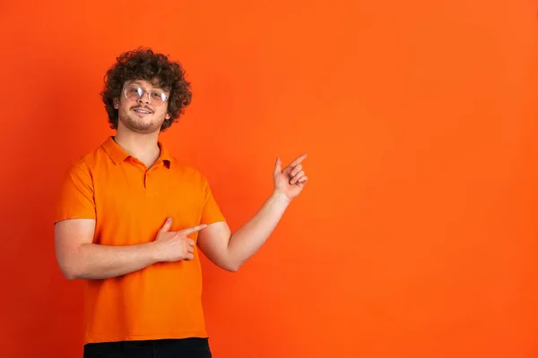 Blanke jonge mannen monochrome portret op oranje studio achtergrond — Stockfoto