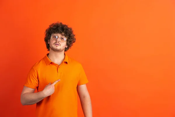 Blanke jonge mannen monochrome portret op oranje studio achtergrond — Stockfoto
