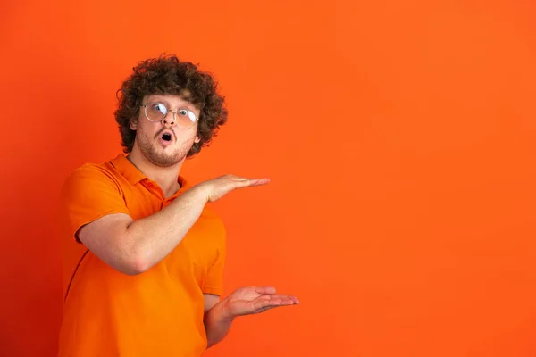 Caucasian young mans monochrome portrait on orange studio background — Stock Photo, Image