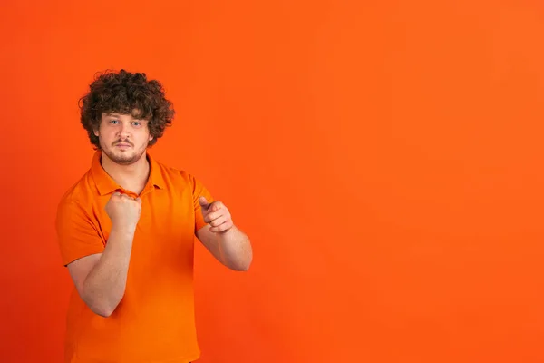 Caucasian young mans monochrome portrait on orange studio background — Stock Photo, Image