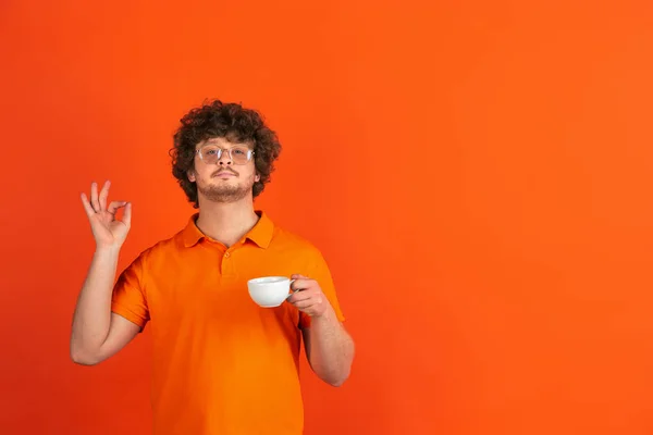 Blanke jonge mannen monochrome portret op oranje studio achtergrond — Stockfoto