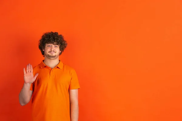 Caucásico joven mans monocromo retrato en naranja estudio fondo — Foto de Stock