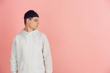 Pembe stüdyo arka planında beyaz genç adam modern portresi