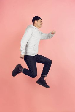 Kafkas genç adam modern portre pembe stüdyo arka planda yüksek atlama