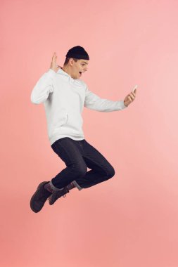 Kafkas genç adam modern portre pembe stüdyo arka planda yüksek atlama