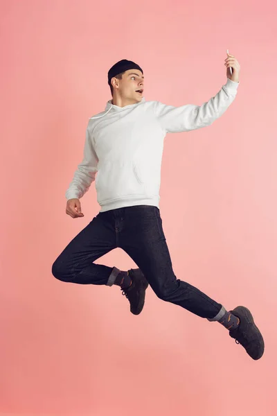 Biały młody mężczyzna nowoczesny portret na różowy studio tło w wysoki skok — Zdjęcie stockowe