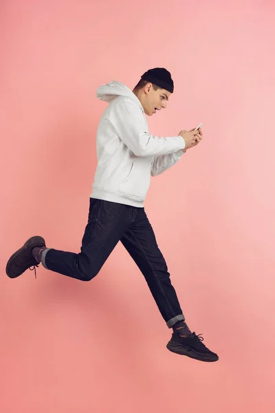 Branco jovem homem moderno retrato em rosa estúdio fundo em salto em altura — Fotografia de Stock