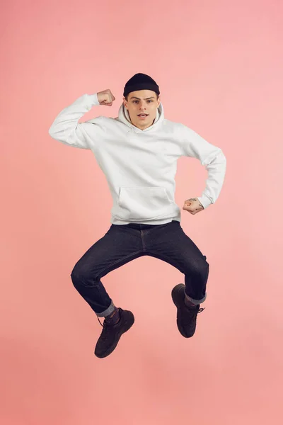 Branco jovem homem moderno retrato em rosa estúdio fundo em salto em altura — Fotografia de Stock