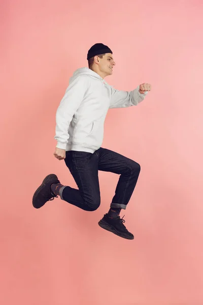 跳高背景下粉红工作室背景的白人年轻人现代肖像 — 图库照片