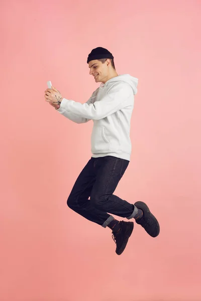 跳高背景下粉红工作室背景的白人年轻人现代肖像 — 图库照片