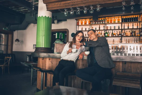 Cheerful man and woman talking, enjoying a coffee at the coffee shop, cafe, bar