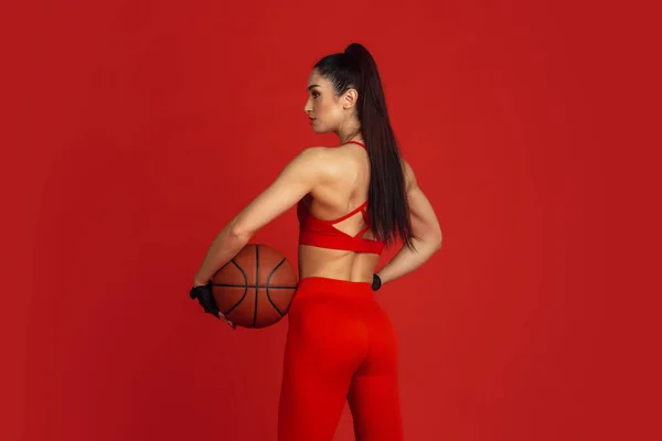 Gyönyörű fiatal női sportoló gyakorló piros stúdió háttér, monokróm portré — Stock Fotó