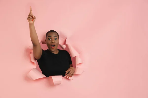 Jovem alegre posa em papel coral rasgado buraco fundo, emocional e expressivo — Fotografia de Stock