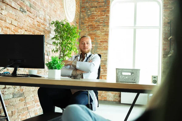 Caucasian doctor consulting for patient, explaining recipe for drug, working in cabinet — Stock Photo, Image