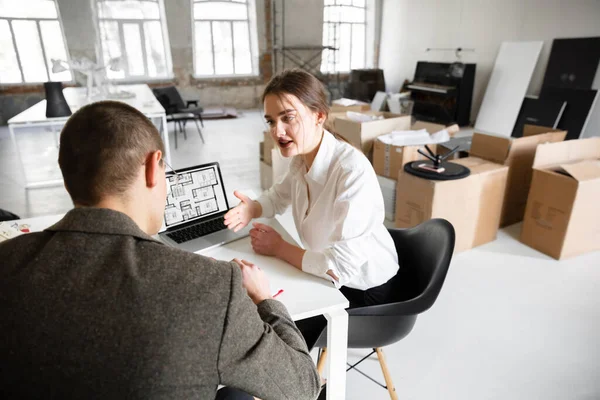 Female estate agent showing new home to a young man after a discussion on house plans, moving, new home concept