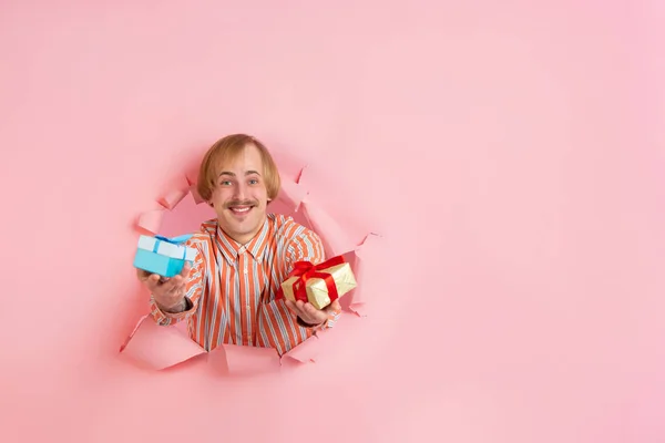 Jovem alegre posa em papel coral rasgado buraco fundo, emocional e expressivo — Fotografia de Stock