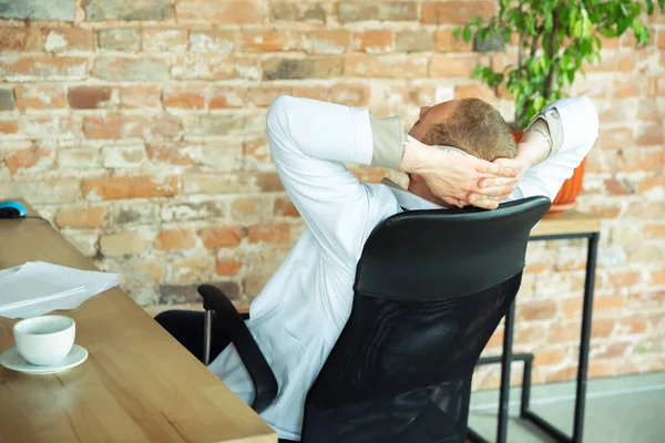 Medico caucasico che si riposa dopo aver consultato il paziente, lavorando nel gabinetto — Foto Stock