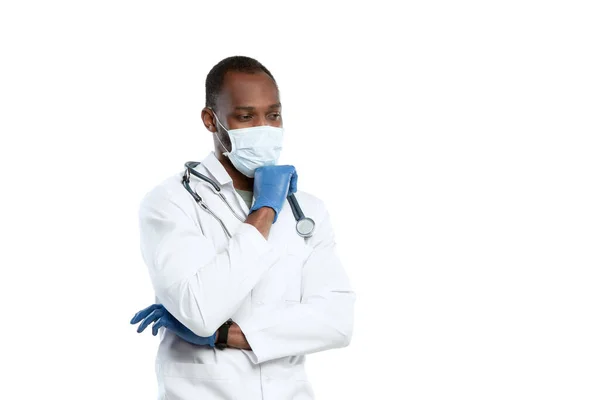 Muž mladý lékař se stetoskopem a obličejovou maskou izolované na bílém pozadí studia — Stock fotografie