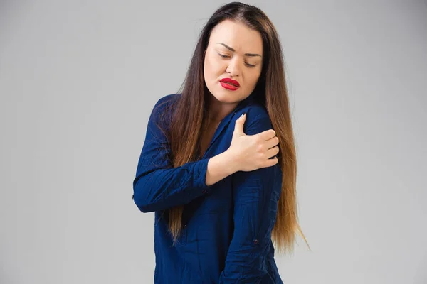 Mulher jovem sofre de dor, sente-se doente, doente e fraqueza isoladas no fundo do estúdio — Fotografia de Stock