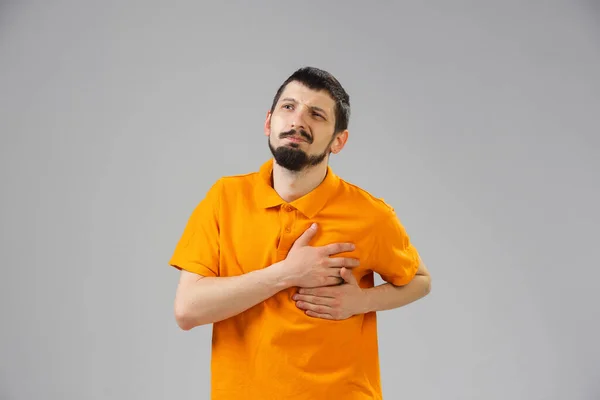 Jongeman lijdt aan pijn, voelt zich ziek, ziek en zwak geïsoleerd op studio-achtergrond — Stockfoto