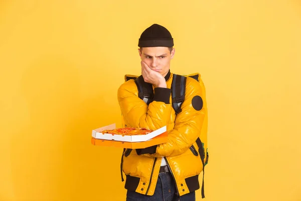 Servicio de entrega sin contacto durante la cuarentena. El hombre entrega comida y bolsas de la compra durante el aislamiento. Emociones del repartidor aisladas sobre fondo amarillo . — Foto de Stock