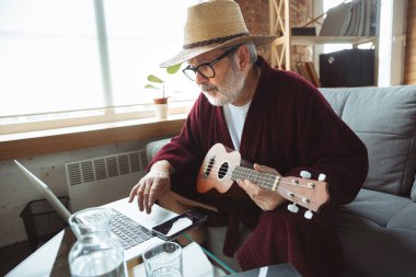 Karantina sırasındaki olgun yaşlı adam virüs salgını sırasında evde kalmanın ne kadar önemli olduğunu fark ediyor ve online gitar çalma dersleri alma konseri veriyor.
