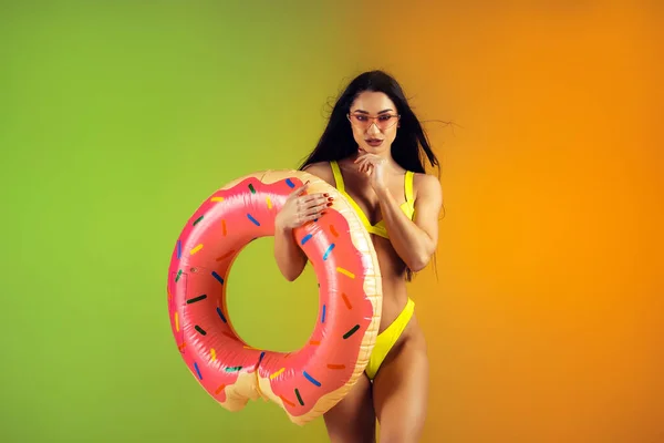 우아 한 노란색 수영복을 입은 젊은 적합 한 여성 과 스포츠적 인 여성의 패션 초상화가 단조 로운 배경 위에 놓여 있다. 여름을 대비 한 완벽 한 몸. — 스톡 사진