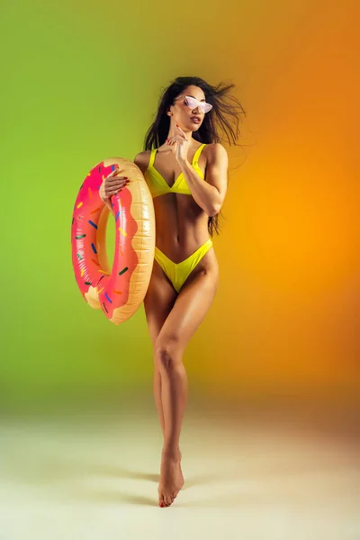 우아 한 노란색 수영복을 입은 젊은 적합 한 여성 과 스포츠적 인 여성의 패션 초상화가 단조 로운 배경 위에 놓여 있다. 여름을 대비 한 완벽 한 몸. — 스톡 사진
