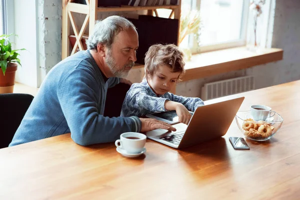 Nonno e suo nipote trascorrono del tempo isolati a casa, stadying, guardando il cinema, shopping insieme — Foto Stock