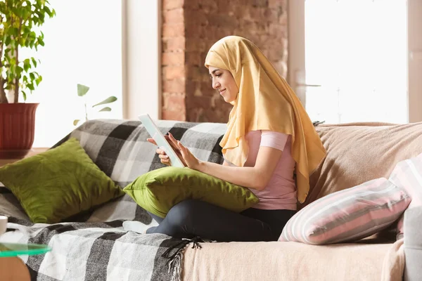 Красивая молодая мусульманка дома во время карантина и самоизоляции, с помощью планшета для селфи или видеоролика, онлайн-уроки — стоковое фото