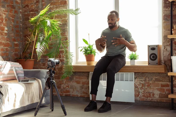 Młody Afrykańczyk-Amerykanin uczy w domu online fitness, aerobiku, sportowego stylu życia podczas kwarantanny, reording przed kamerą, streaming — Zdjęcie stockowe
