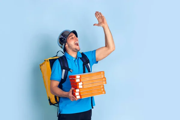 Bezkontaktní doručení během karantény. Muž doručuje jídlo a nákupní tašky během izolace. Emoce doručovatele izolované na modrém pozadí. — Stock fotografie