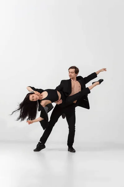 Jovens e graciosos bailarinos em estilo preto mínimo isolado no fundo do estúdio branco — Fotografia de Stock