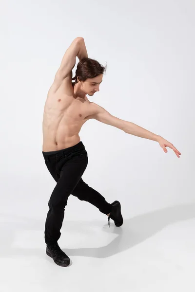 Joven y elegante bailarina de ballet en estilo minimalista negro aislado sobre fondo de estudio blanco — Foto de Stock