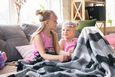 Sessiz küçük kızlar güzel pijamalarıyla bir yatak odasında uyanıyor. Ev tarzı ve konforlu.