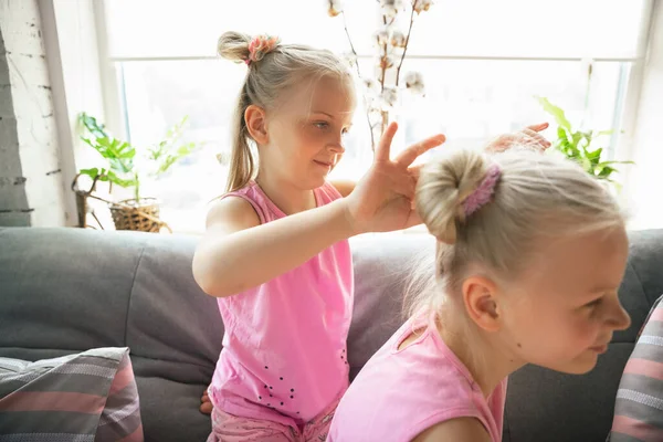 Ciche dziewczynki bawiące się w sypialni w cute piżamy, styl domu i komfort, co fryzurę — Zdjęcie stockowe