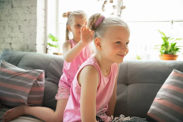 Meninas tranquilas brincando em um quarto em pijama bonito, estilo de casa e conforto, fazendo um penteado — Fotografia de Stock