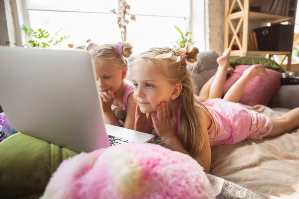 Niñas tranquilas jugando en un dormitorio en pijama lindo, estilo casero y comodidad, viendo dibujos animados, cine, divertirse — Foto de Stock