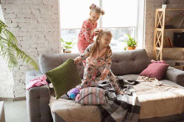 Tiché holčičky hrají v ložnici v roztomilé pyžamo, domácí styl a pohodlí, smích a bojové polštáře — Stock fotografie