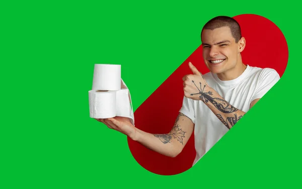 Portret van een jongeman op een heldere bicolor achtergrond met geometrische stijl, modern design, kunstwerk. WC-papier vasthouden, eng glimlachen en omhoog duimen — Stockfoto