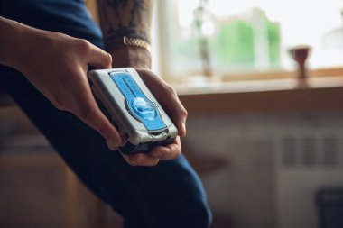 Eski oyuncakları kullanan, geçmişten gelen şeylerle buluşan ve eğlenen, müzik kasedini çalan gençlere yakın çekim.