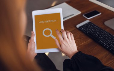 Dünya çapında koronavirüs salgını krizinde iş ararken kadın elleri tablet kaydırıyor. İnternetten iş bul. İş, İnternet ve ağ oluşturma kavramı.