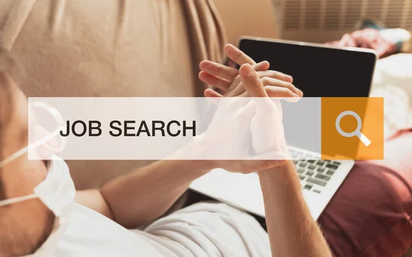 Man som söker jobb under en världsomfattande kris av coronaviruspandemi. Hitta ett jobb på nätet. Affärs-, internet- och nätverkskoncept. — Stockfoto