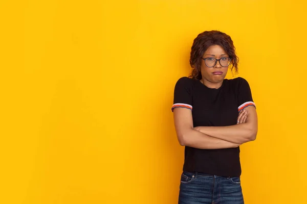 Afro-Amerikaanse mooie jonge vrouwen portret op gele studio achtergrond, emotioneel en expressief. Copyspace voor reclame. — Stockfoto