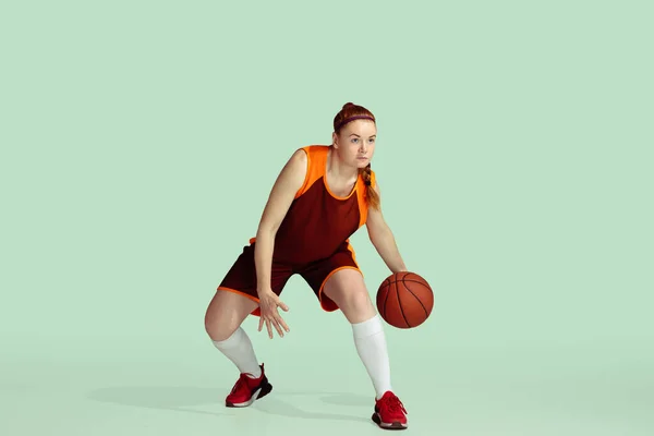 Ung kaukasisk kvinnlig basketspelare mot mynta färgade studio bakgrund — Stockfoto