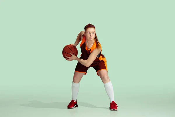 Jeune caucasienne joueuse de basket-ball contre fond studio couleur menthe — Photo